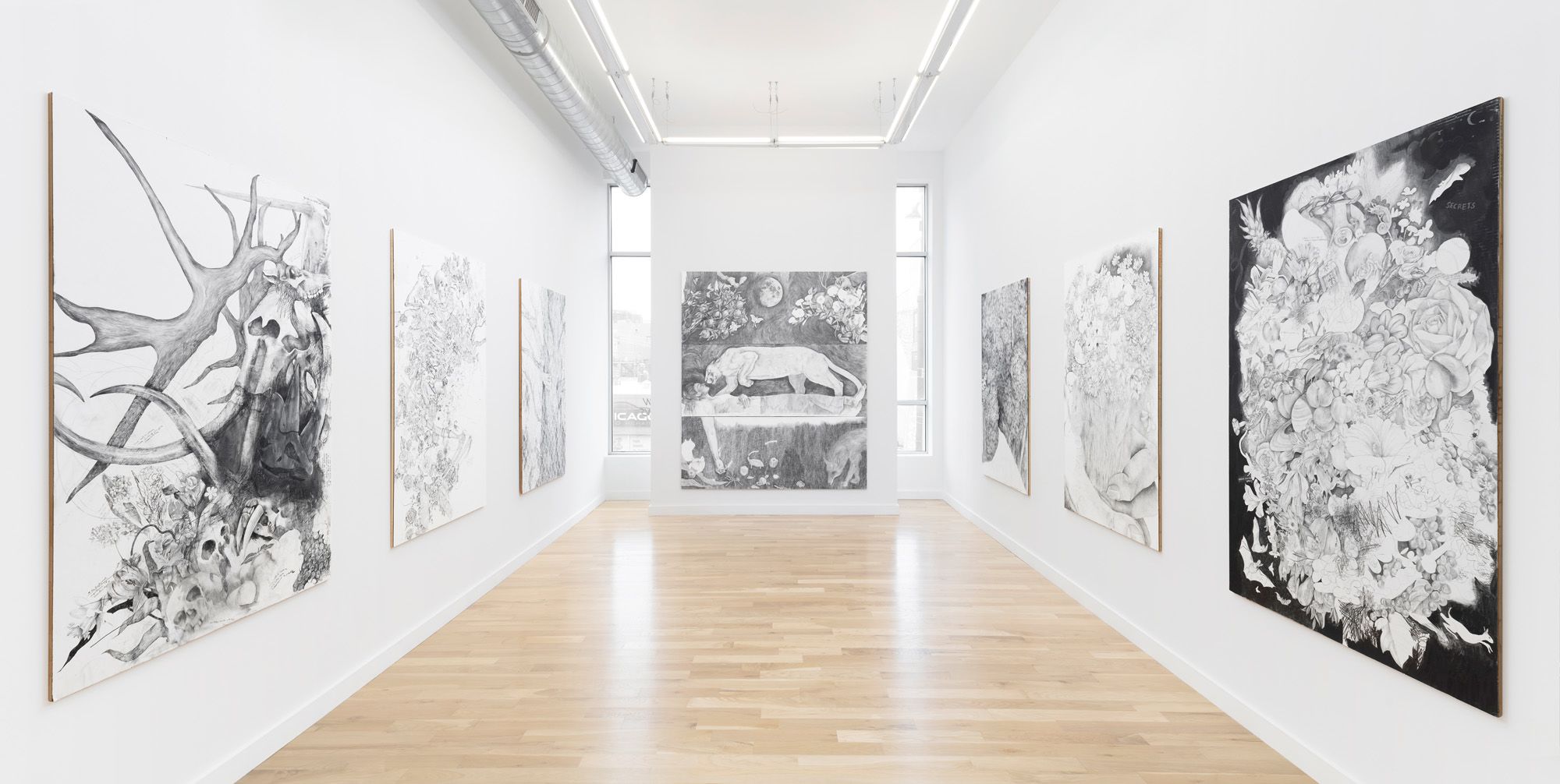 An installation featuring several large, black and white canvases 