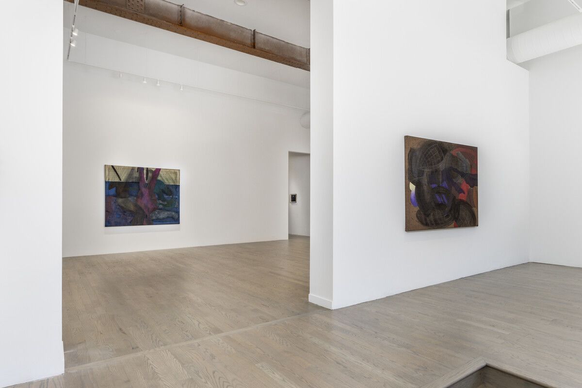 A gallery with white walls and two paintings