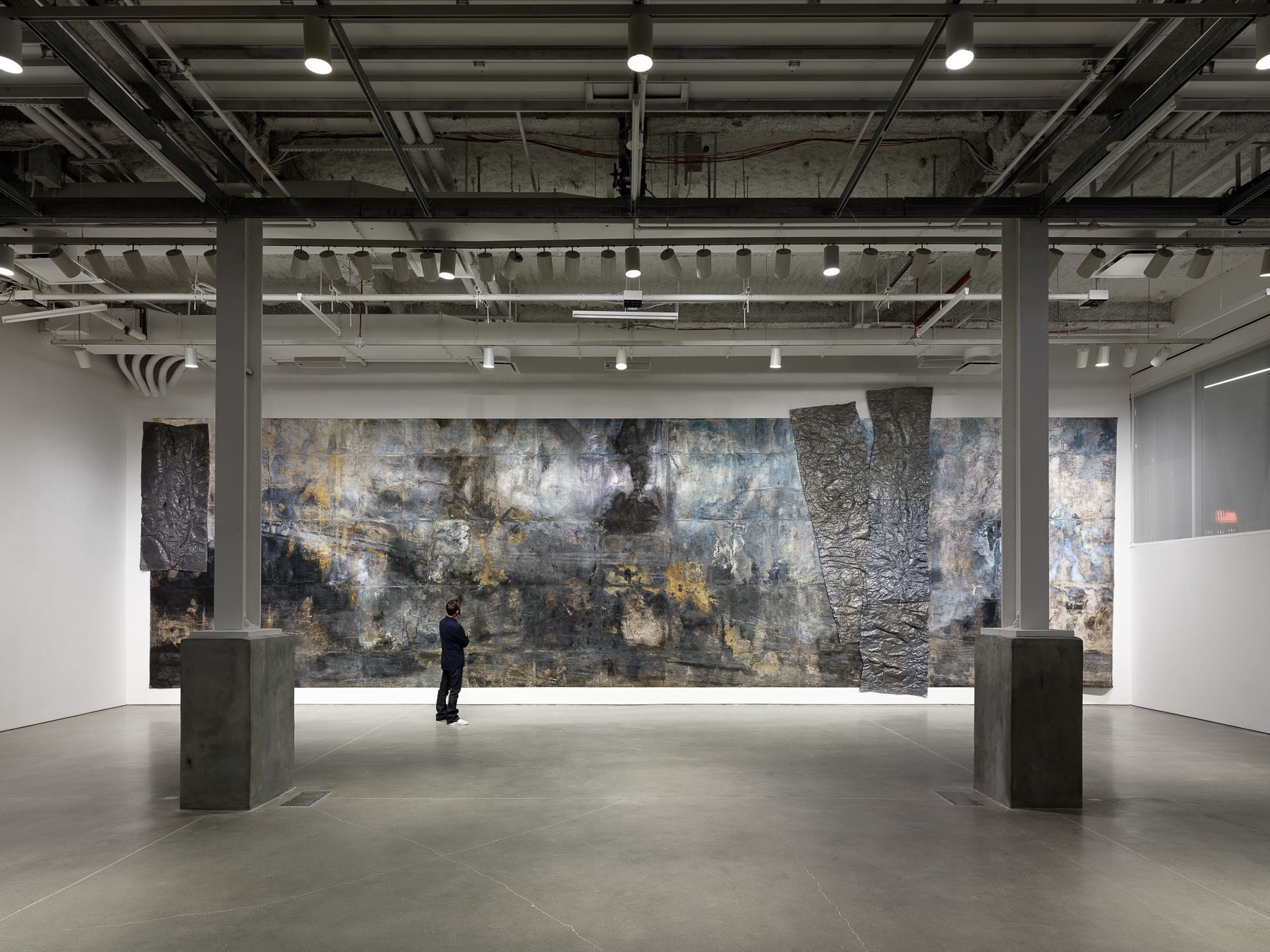 A gallery space with an art piece taking up an entire wall.