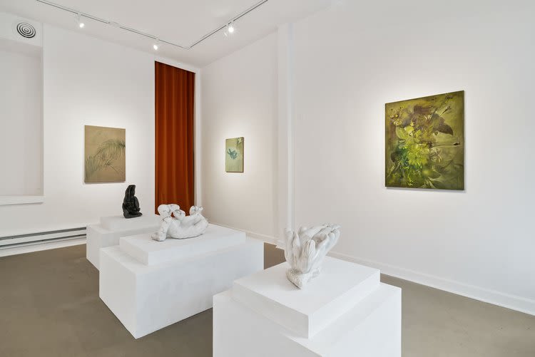 An installation view of several scupltures and paintings