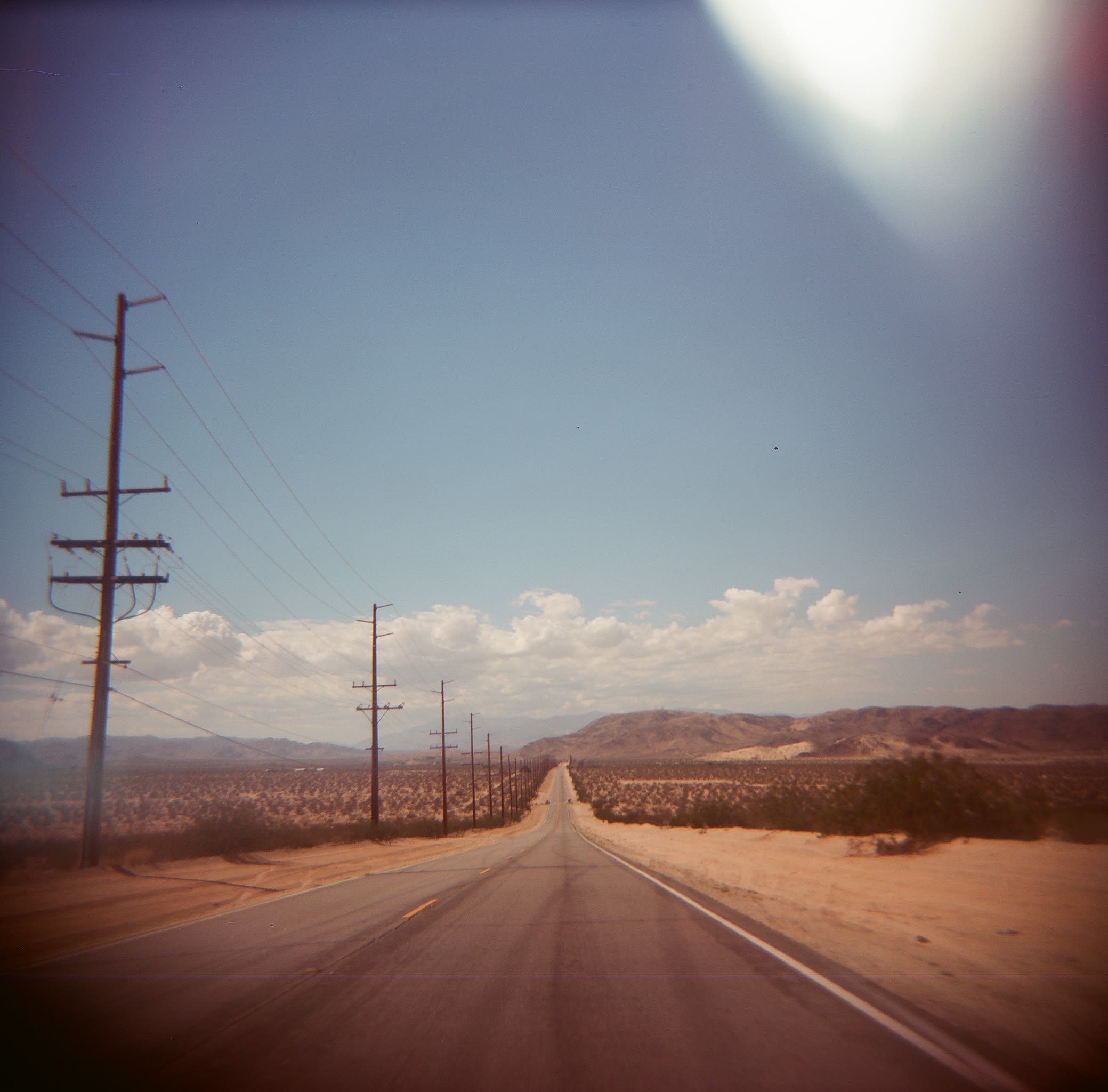 A rode and telephone lines receding into the horizon. 