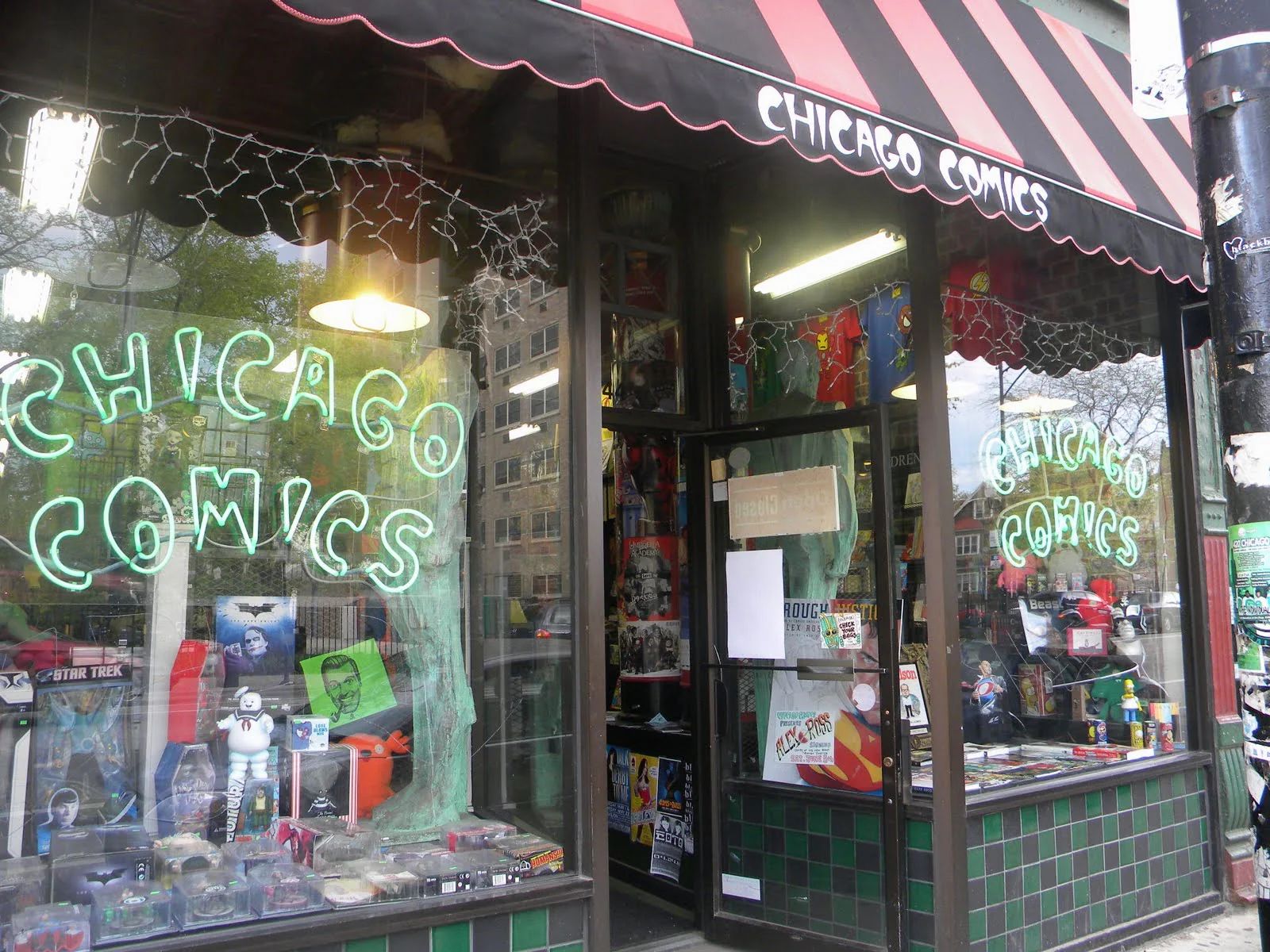 The exterior of a comic shop with a neon sign saying Chicago Comics