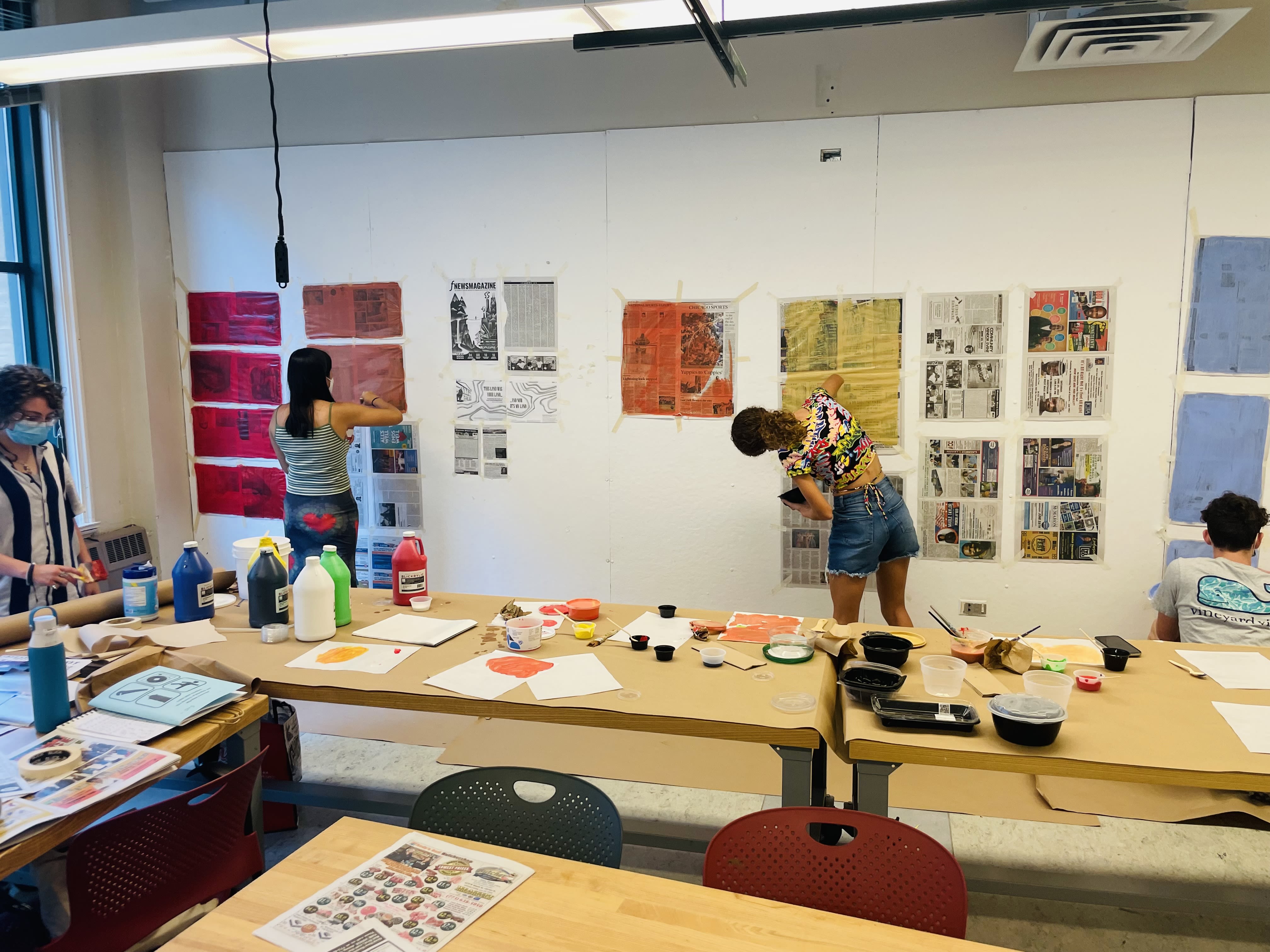 Students pin work up in a classroom