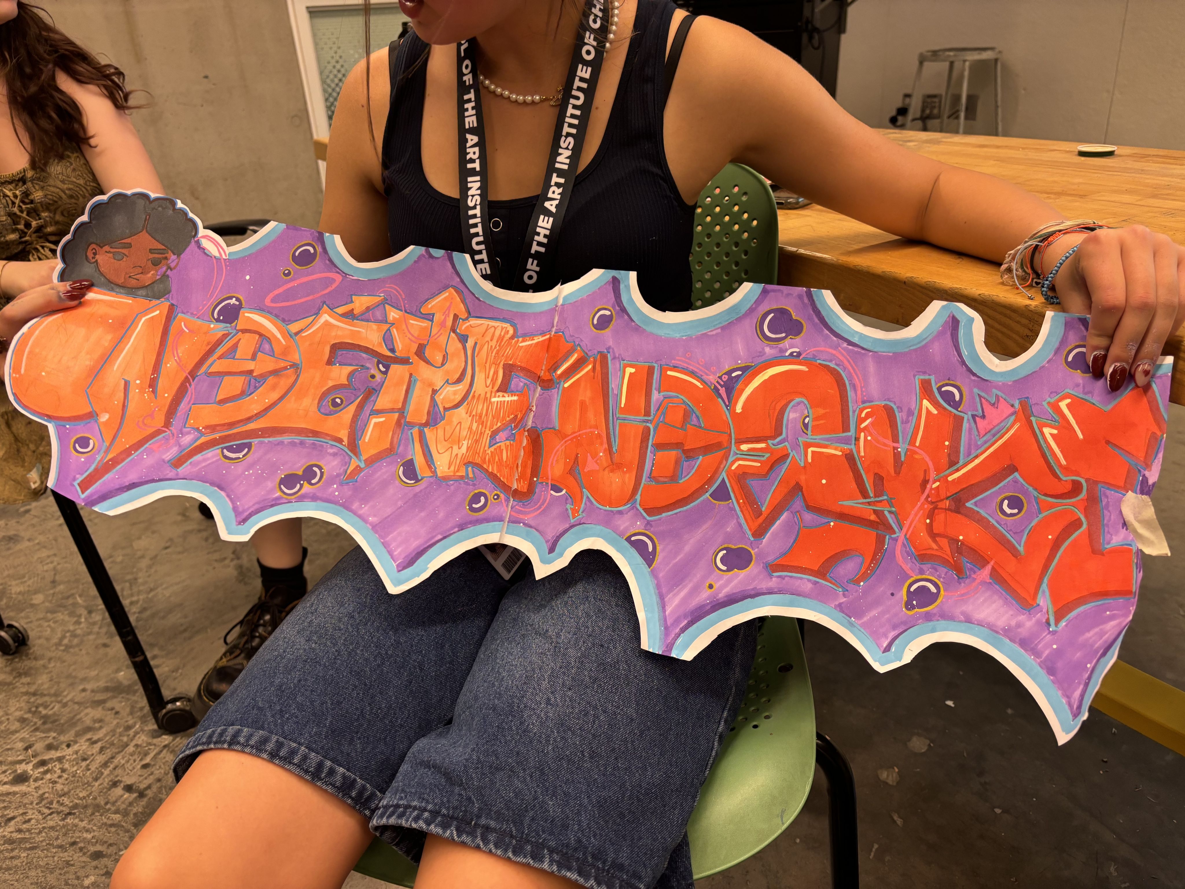 A student holds a piece of art