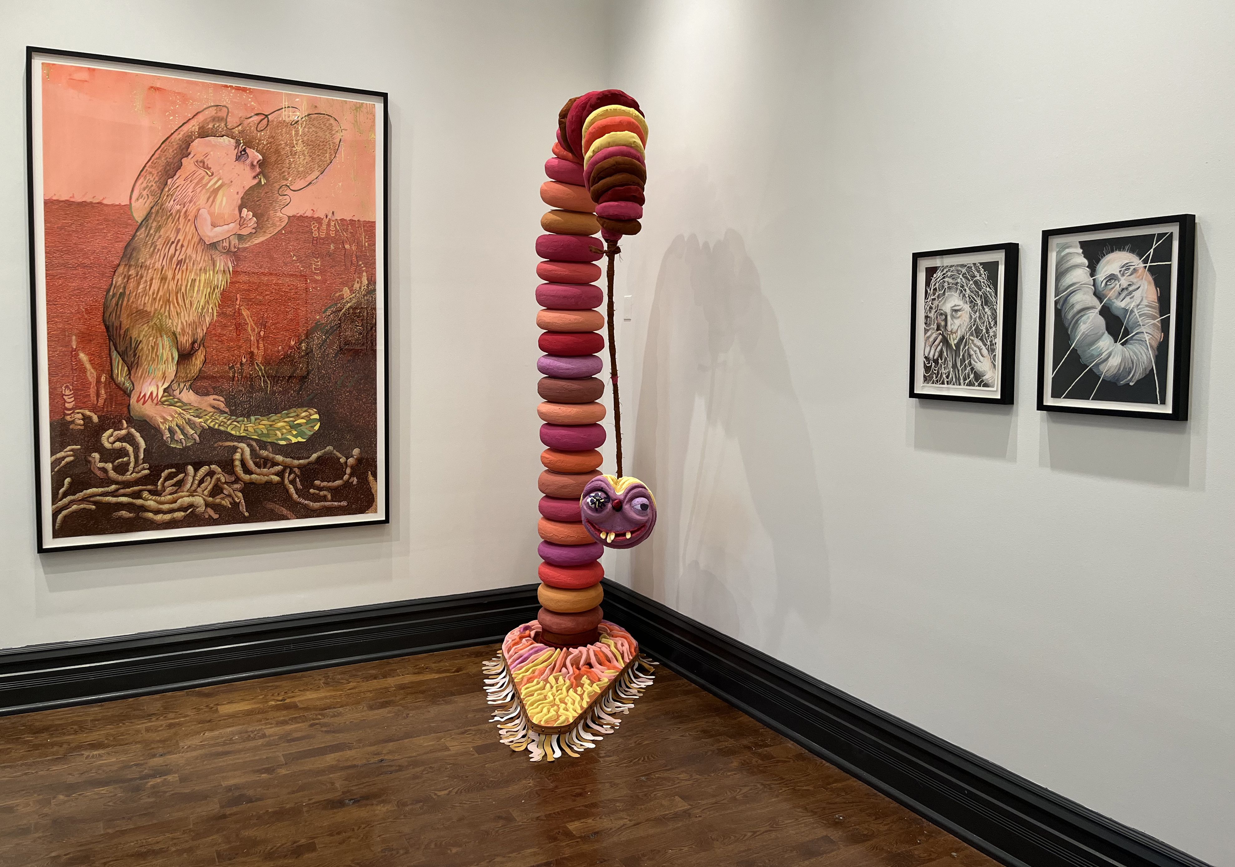 A gallery showing paintings and a sculpture of a colorful creature