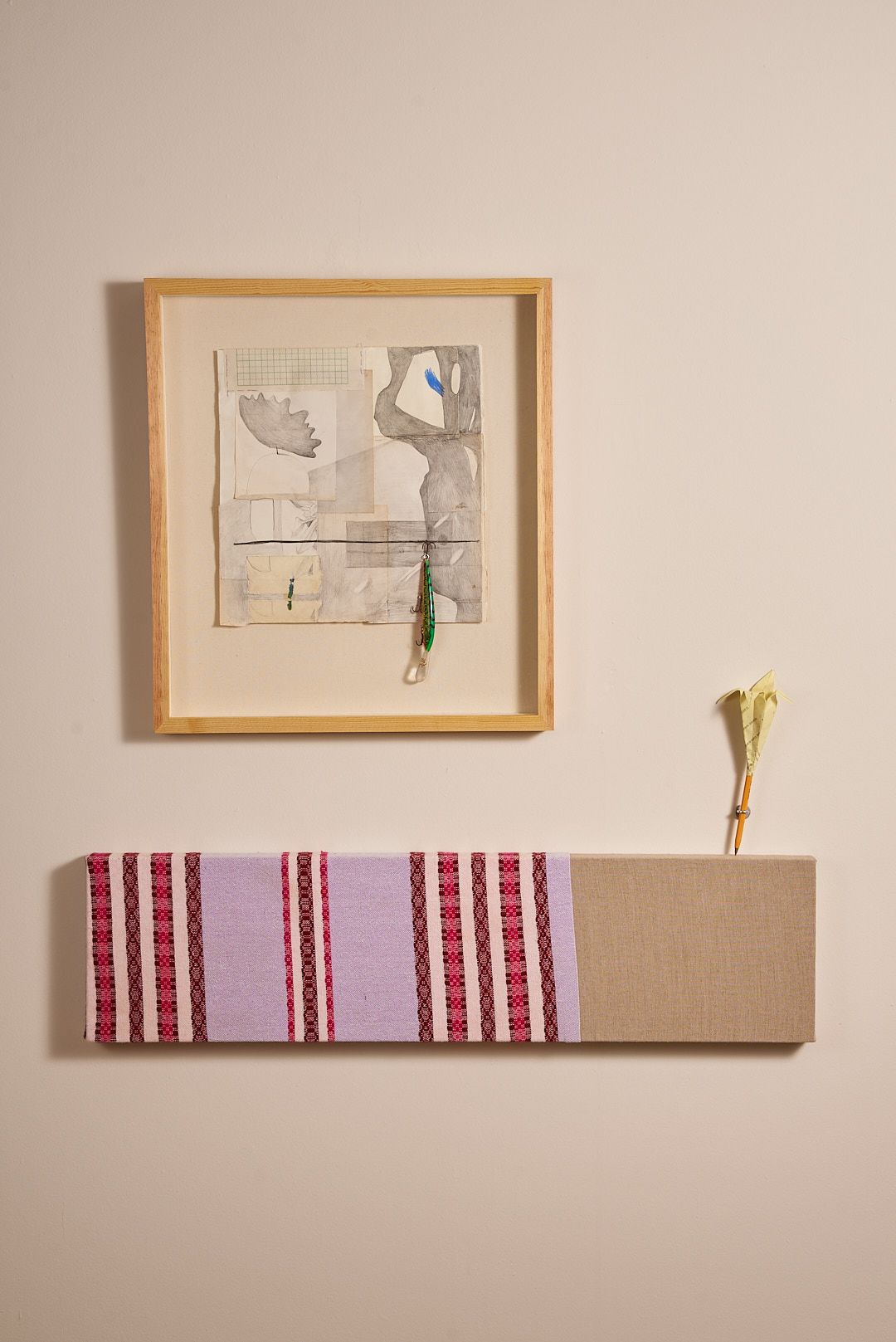 A drawing and fiber piece mounted on a wall