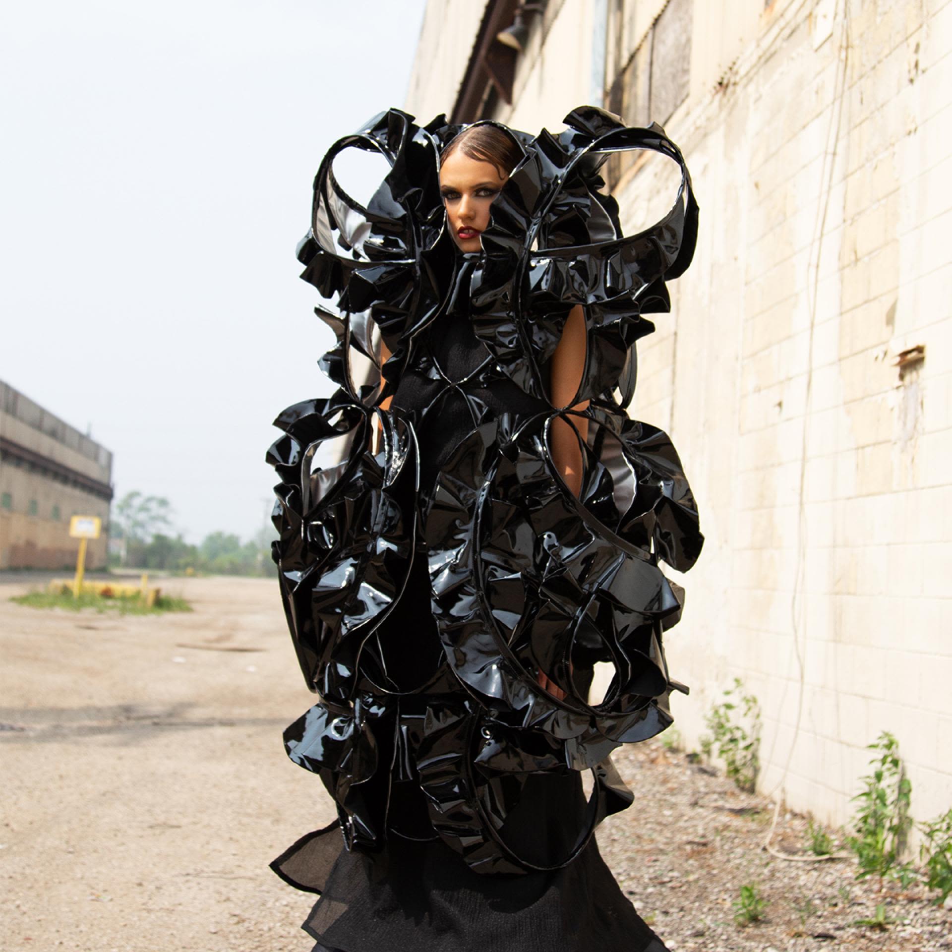 A model wears a black sculptural work of art