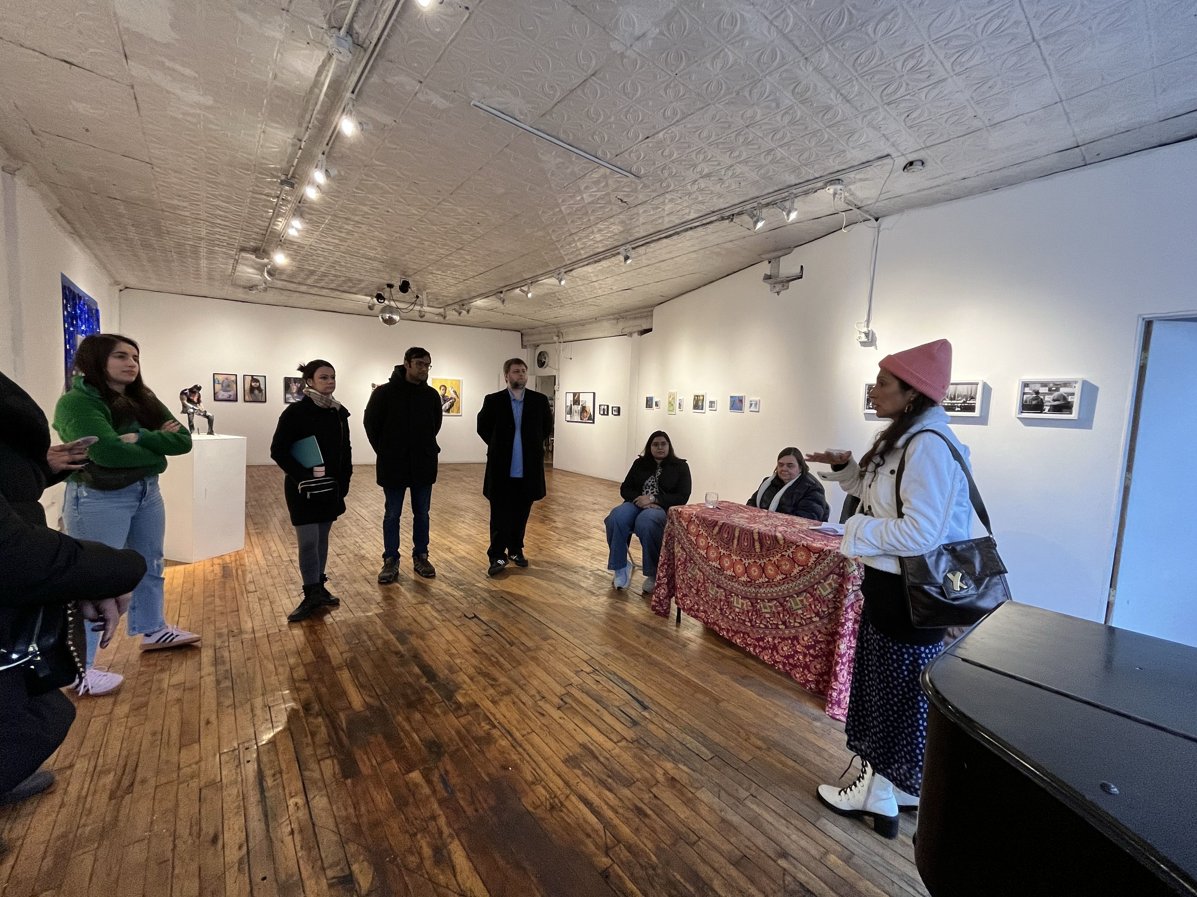 Students in a gallery space listen to a speaker