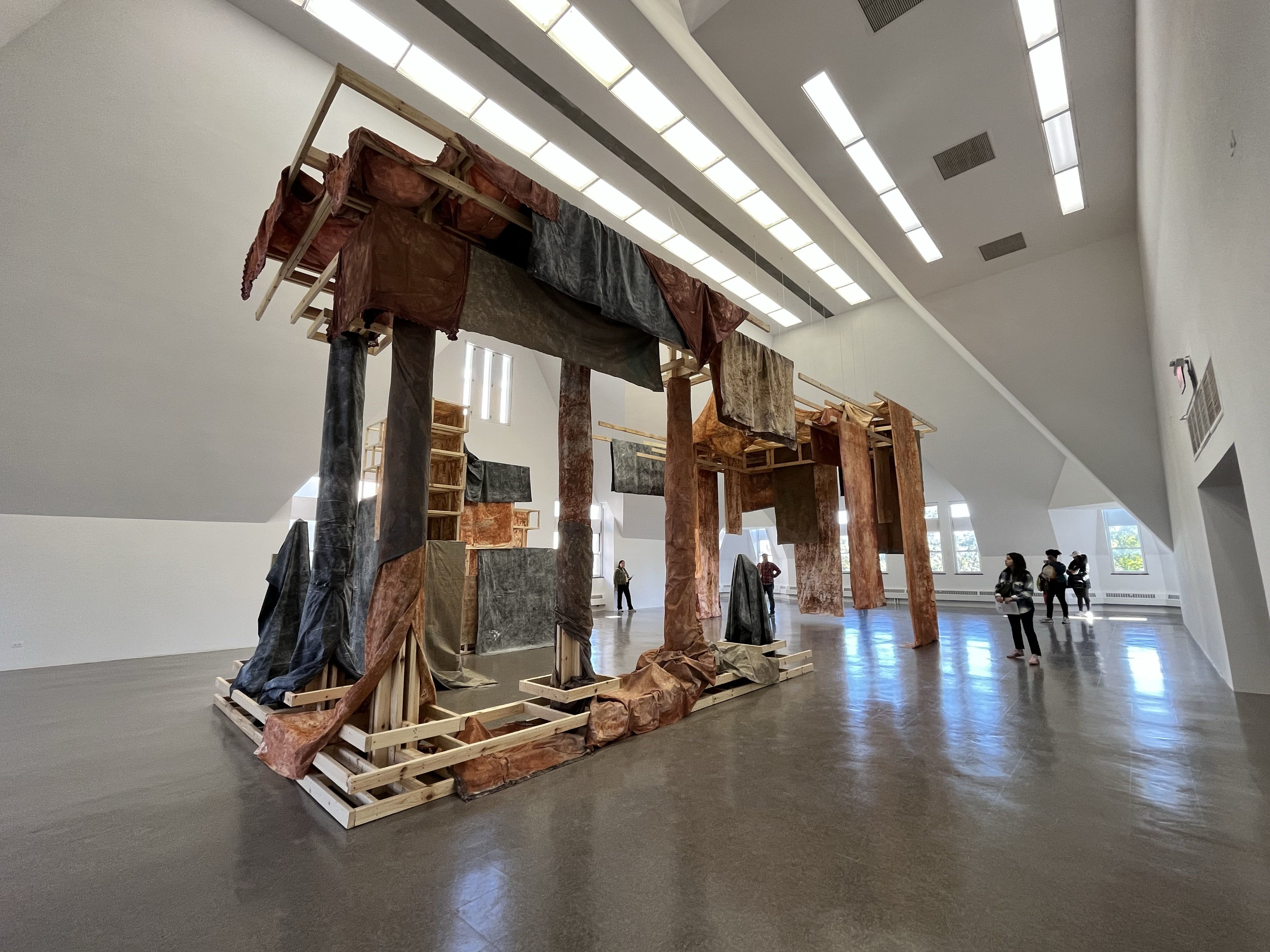 A gallery space with a large structure hung with fabric