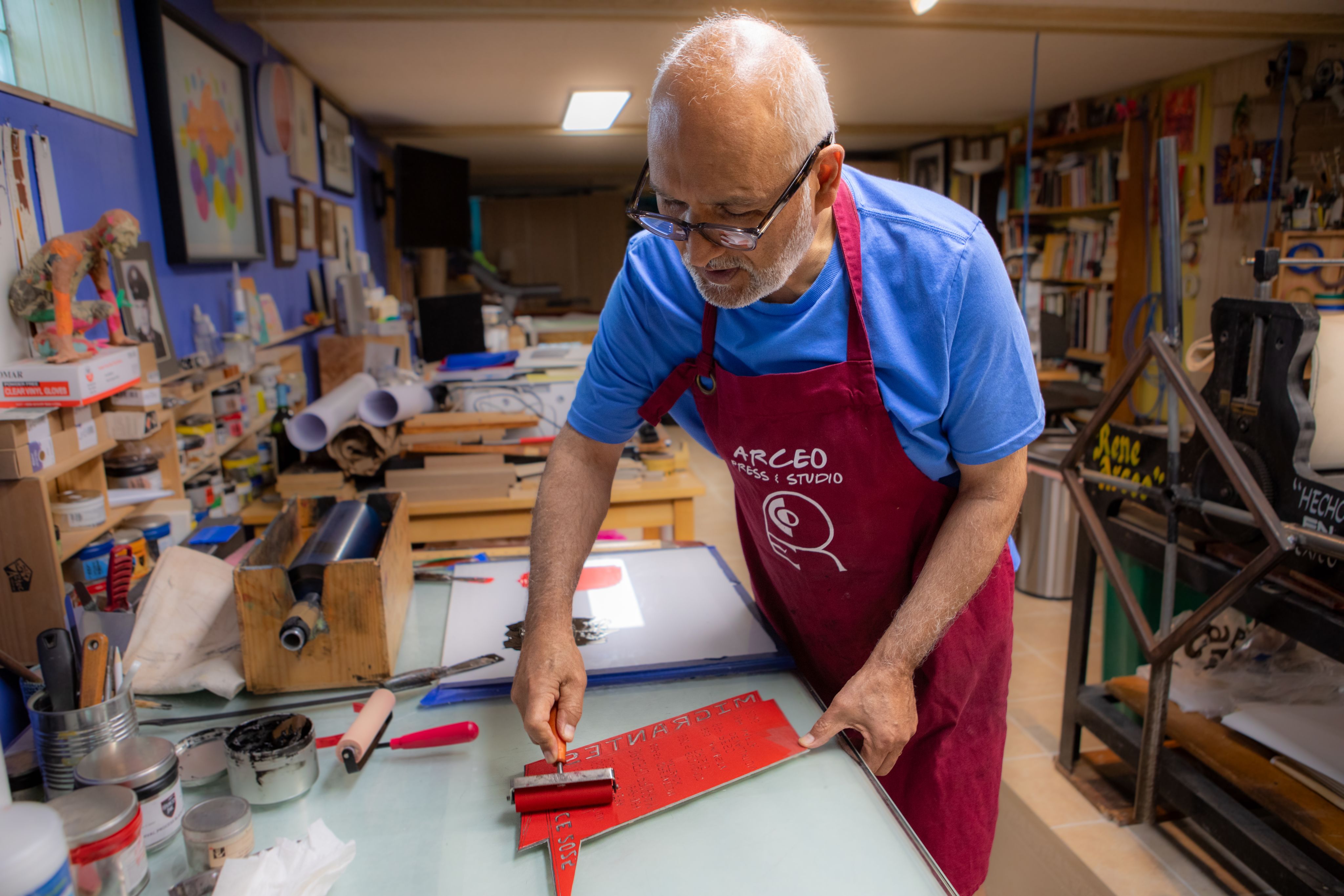 An artist uses a roller in his studio