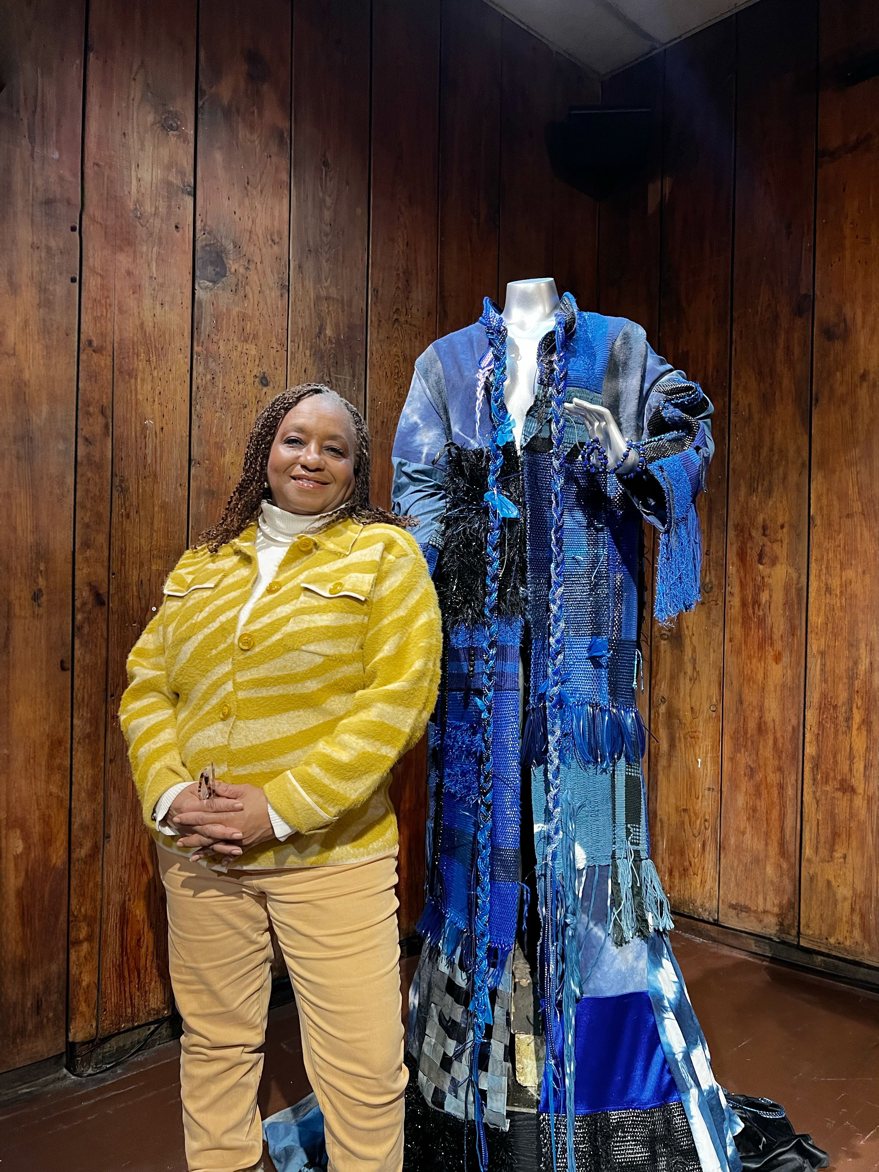 Jacqueline Williams stands in front of a mannequin in a blue robe