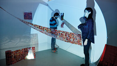 Two people standing in a gallery. 