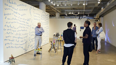 People standing and talking in art gallery