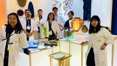 A group of students gathered in front of their designed products.
