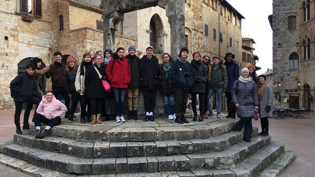 A group of students posing in an old Italian town.