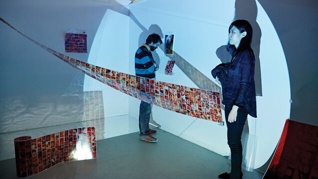 Two people standing in a gallery. 