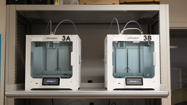 Two 3D printers on a shelf