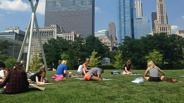  A group of students sitting outside in the park.