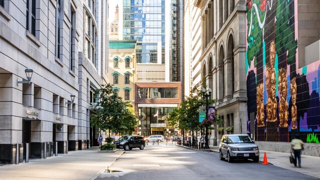 City street with buildings, cars, and trees.