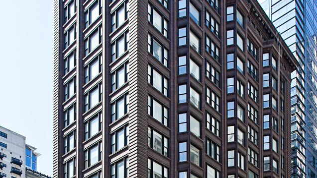 A box-shaped building next to a tall office building in Chicago.