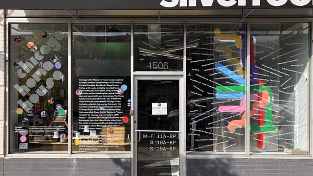 Street view of a building showing store hours on the door.