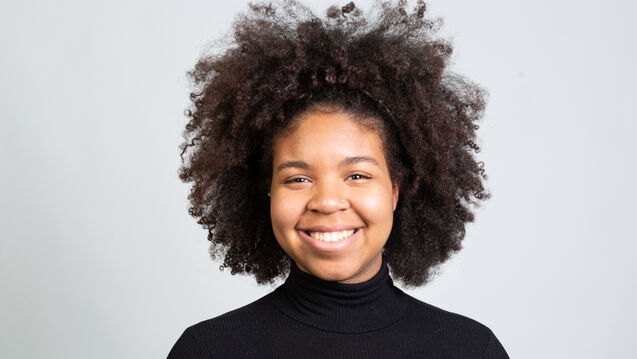 Jada in a black outfit smiling at the camera
