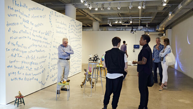 People standing and talking in art gallery