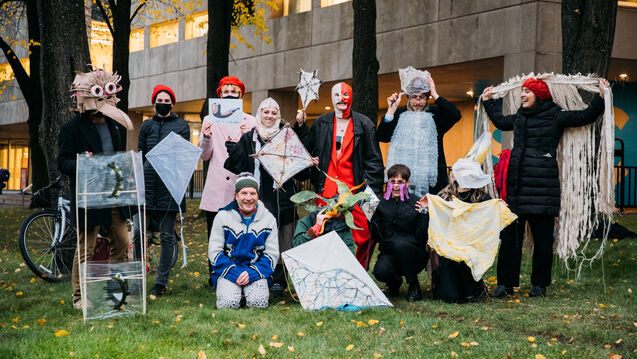 A group of students in costumes holding kites.