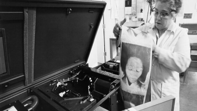 Black and white image of Sonia Sheridan using a copy machine.