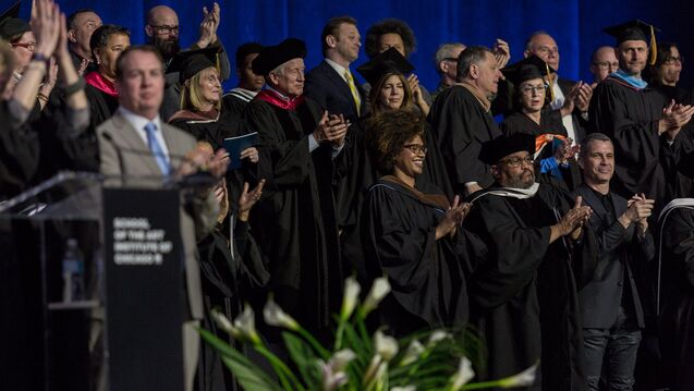 A group of faculty in caps and gowns at commencement