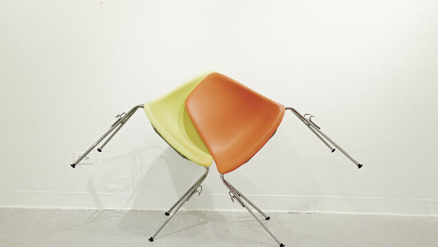 Artwork containing two chairs supporting each other