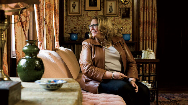 A professor sits in an ornate living room