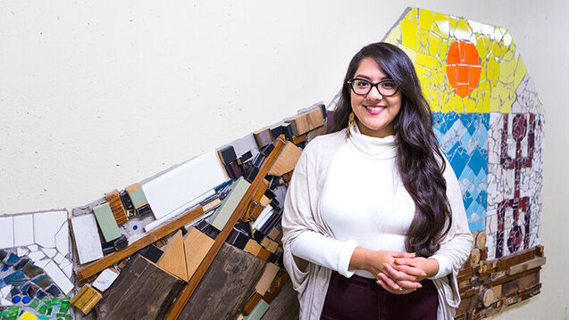 A person stands in front of a multimedia art piece