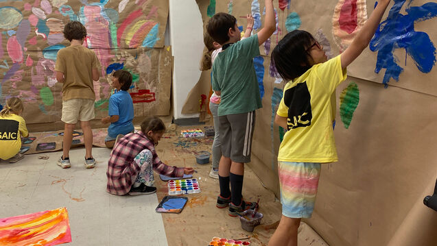 multi-arts camp students painting a mural