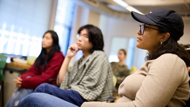 A group of four students of varying ethnicities and genders looking at an out-of-frame subject. 