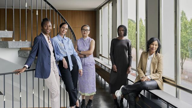 ive women stand and sit in a bright hallway by a staircase. From left: Naomi Beckwith, Carla Acevedo-Yates, Xiaoyu Weng, Mayra A. Rodríguez Castro, and Romi Crawford.