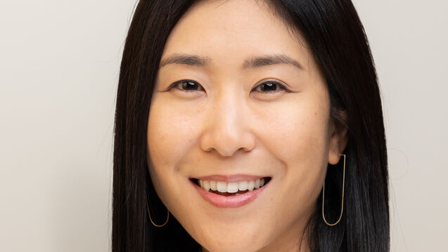 Headshot of Younsoo Kim Flynn, an adult Asian person with a medium-fair skin tone and short dark hair. 