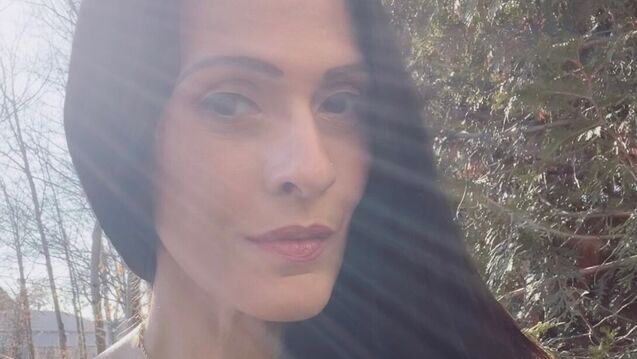 An outdoor selfie of Cynthia Pelayo, an adult person with a fair skin tone and long dark hair.