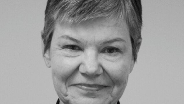 Black and white headshot of Kate Schutta, an adult person with a fair skin tone and pixie cut. 