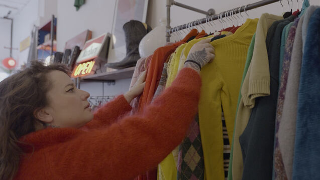 Maddie Rogers adjusts clothes on a rack