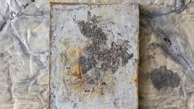 An abstract painting against a rough wall