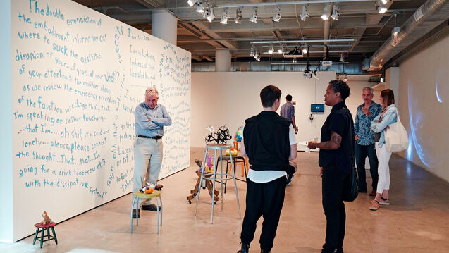 People standing and talking in art gallery