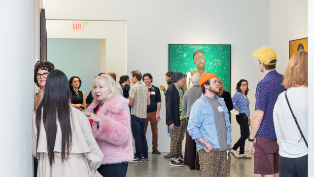 Adults of varying ages, ethnicities, and genders at an event in a gallery. 