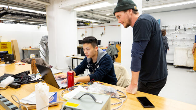Two students looking at a laptop computer.