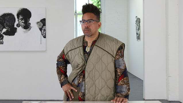 An artists stands in a modern gallery space