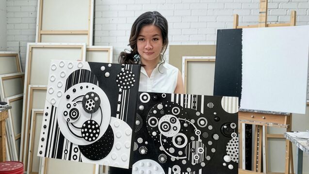 My Linh holding two paintings