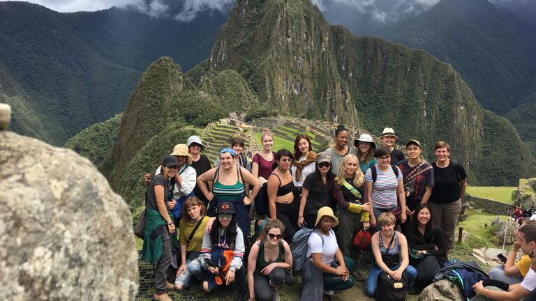 A group of SAIC students and faculty members smile for the camera in front of Machu Picchu.