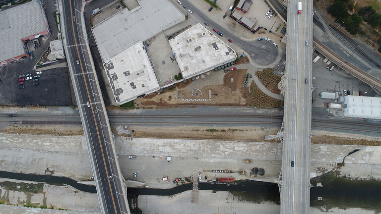 A drone shot showing a run-down urban environment and highways.