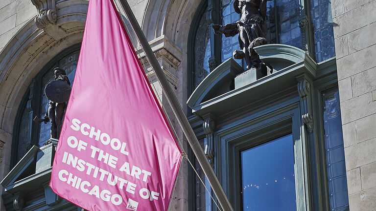 Exterior shot of a pink SAIC flag at the MacLean Center entrance.