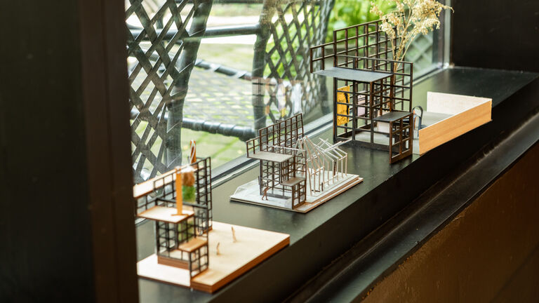 An image of a few small, wooden models on a windowsill. 